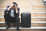 Business stress and sitting on stair with baggage in city outdoor