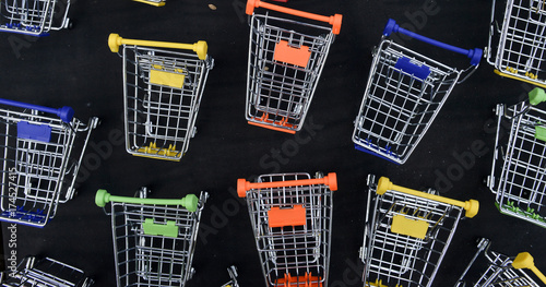  colorful toy shopping metal trolleys on black background