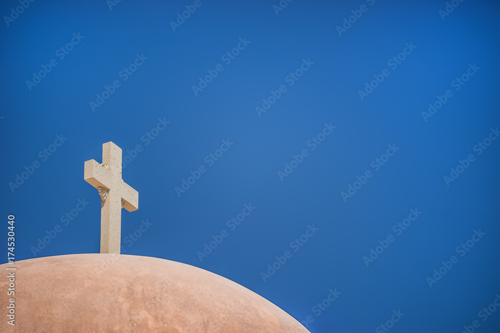 White Christian cross in front of a blue sky with copyspace White Christian cross in front of a blue sky with copyspace