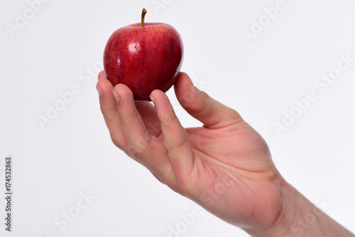 Male hand holds red apple. Apple in bright juicy color