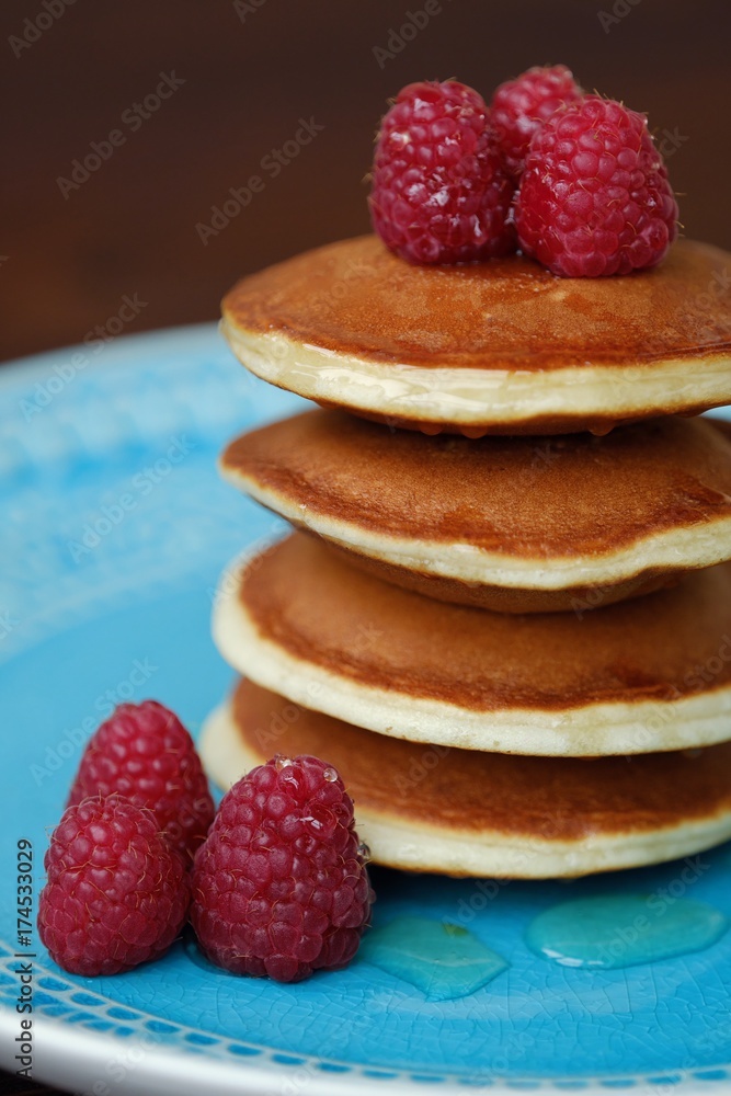 Delicious pancakes with raspberries and honey in a bowl Delicious pancakes with raspberries and honey in a bowl