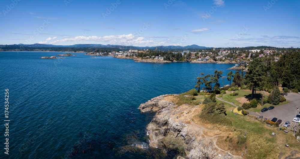 Fototapeta premium Aerial panoramic landscape view of a beautiful rocky shore on Pacific Coast. Taken in Saxe Point Park, Victoria, Vancouver Island, British Columbia, Canada.