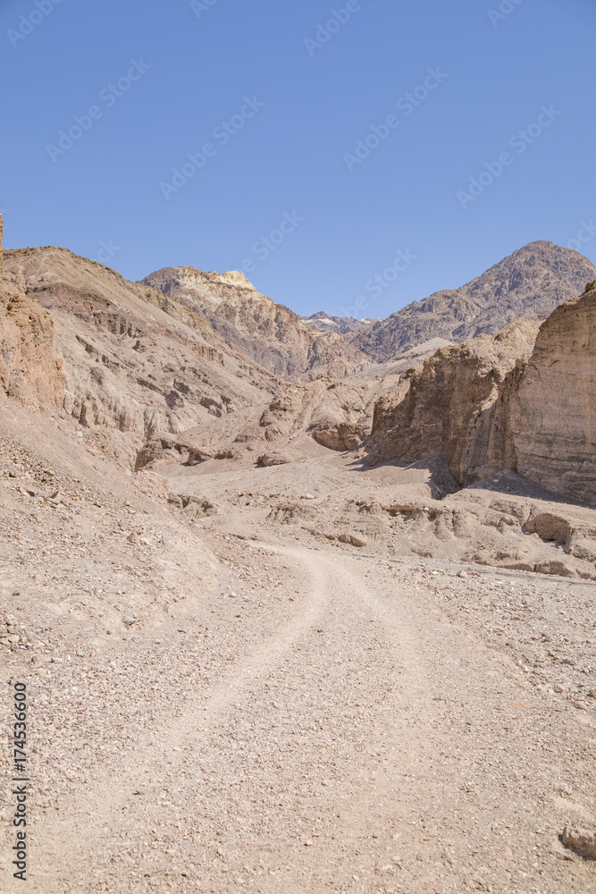 A dirt track running through canyons in Death Valley, California