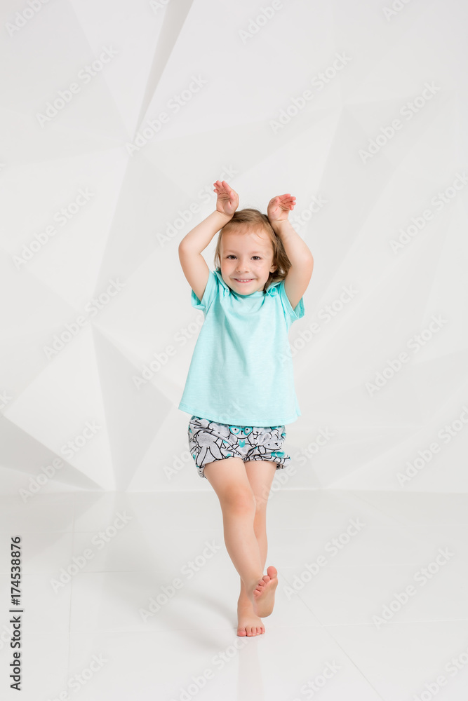 Beautiful little fashion model on white studio background. Portrait of cute girl posing in studio Beautiful little fashion model on white studio background. Portrait of cute girl posing in studio