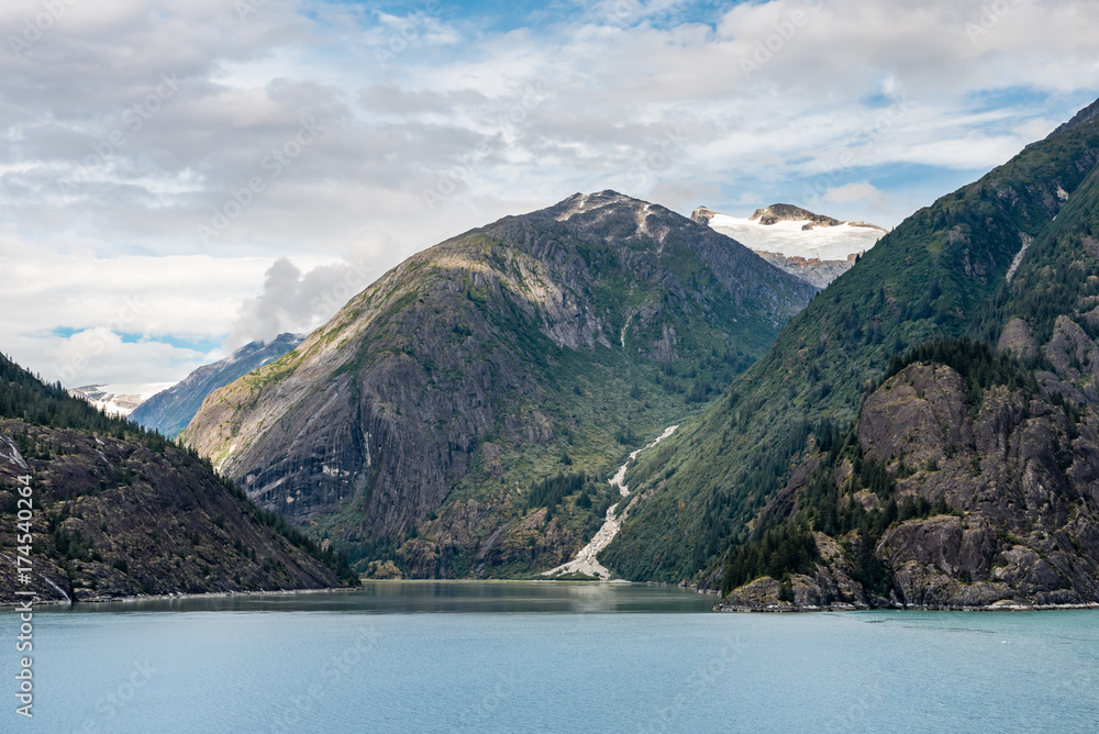 View up an Alaskan fjord to a hillside waterfall