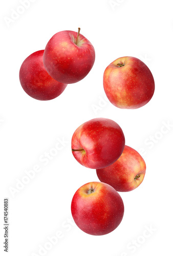 Falling red apples isolated on white.