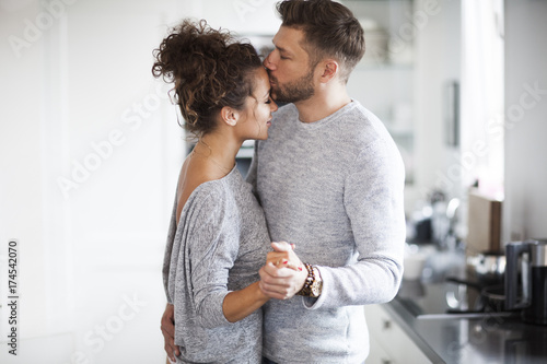 Intimate couple is dancing in the kitchen. Passion in the house.