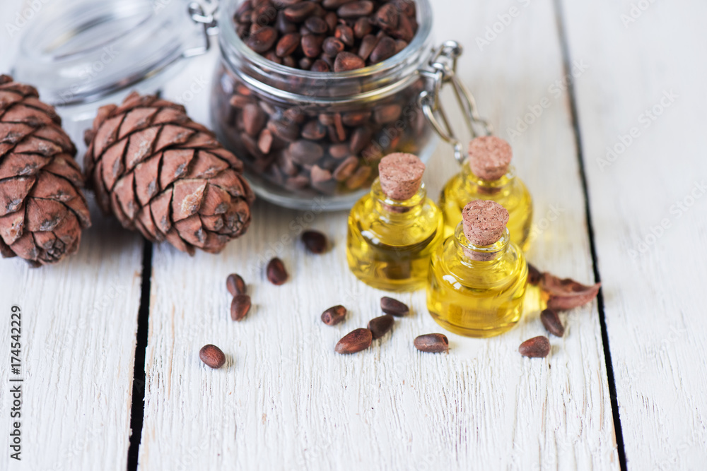 Oil of cedar nuts on a white wooden background Oil of cedar nuts on a white wooden background