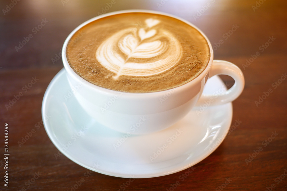 Hot coffee latte cup on wood table background with warm morning sunlight, shallow depth of field. Hot coffee latte cup on wood table background with warm morning sunlight, shallow depth of field.