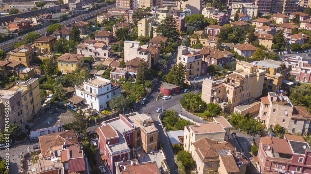Vista aerea di palazzi adibiti ad uso residenziale nella zona est della città di Roma. Tra le case e le via crescono tanti alberi alti che donano un pò di verde e aria pulita alla metropoli.
