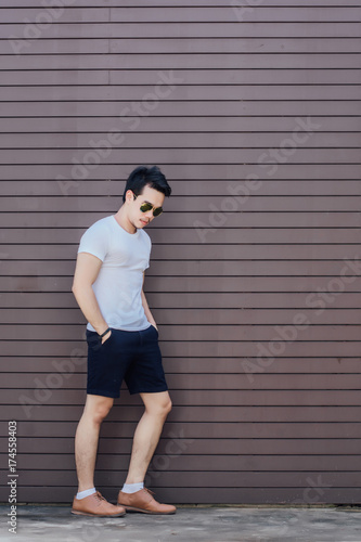 Portrait photo of young man posing against wooden background,fashion style.