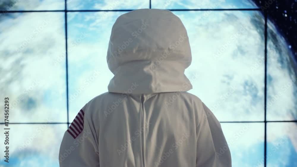 Astronaut looking through window at view of planet earth Astronaut looking through window at view of planet earth