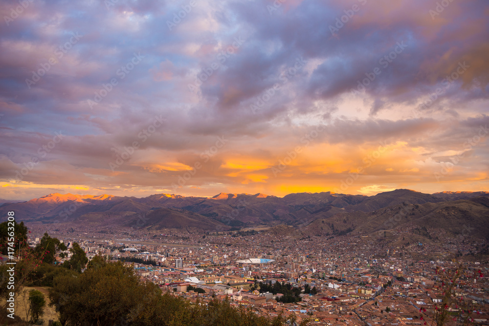 Panoramic view of Cusco town with glowing cloudscape and colorful sky at dusk. Cusco is among the most important travel destination in Peru and the entire South America.