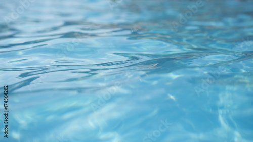 Surface of blue water close-up. Texture of water surface in pool