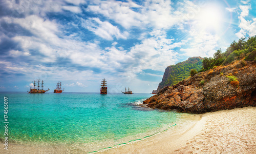 paradise tropical sea bay with ships. Landscape of sea, rocks on beach with white sand. Lagoon in summer sunny day. Turkey.
