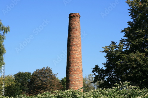 Old stack / chimney made of red bricks stands in the open park area