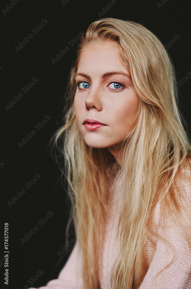Portrait of a young blonde girl on a black background in the studio Portrait of a young blonde girl on a black background in the studio