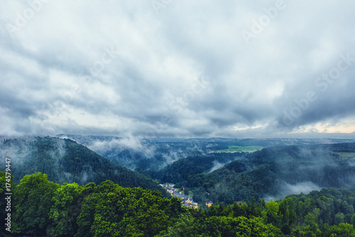 Beautiful view on a small town in the mountains with a dramatic cloudy sky.