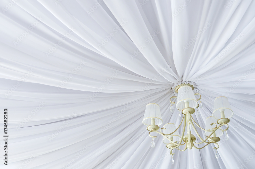 Classic chandelier hanging on ceiling made of white cloth. View from bottom. Classic chandelier hanging on ceiling made of white cloth. View from bottom.