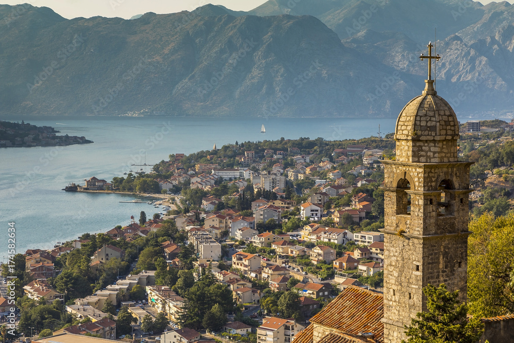 вид на город Котор на берегу залива в Черногории на фоне колокольни католической церкви 