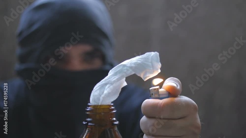 Black bloc anarchist is lighting molotov cocktail