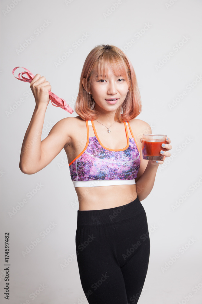 Healthy Asian girl diet with tomato juice and measuring tape on diet. Healthy Asian girl diet with tomato juice and measuring tape on diet.