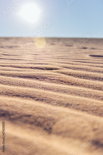 Sun flare and shadows amonsgt the wind blown ripples in the sand dunes of the Ningaloo Coast photo