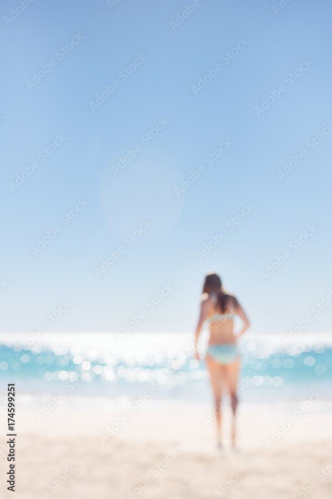 Teenage girl in a turquoise bikini walking to the sparkling water of the Indian Ocean Teenage girl in a turquoise bikini walking to the sparkling water of the Indian Ocean