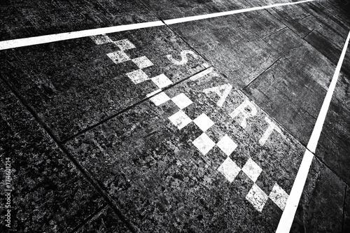 Grunge textured start pattern line sign on the asphalt road.