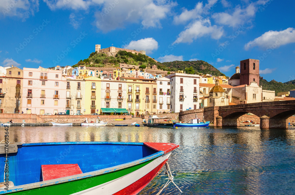 Colourful boat on background of beautiful buildings of Bosa, Sardinia, Italy