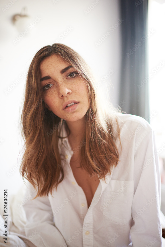 Dark haired model in white shirt looking at camera Dark haired model in white shirt looking at camera