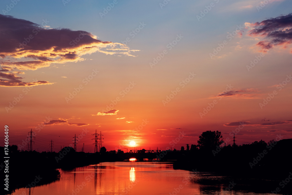 Red Sunset By The River With Reflections And Silhouettes Of Industrial Area