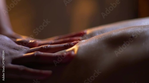 massage of the female back. hands of the masseuse, foot massage