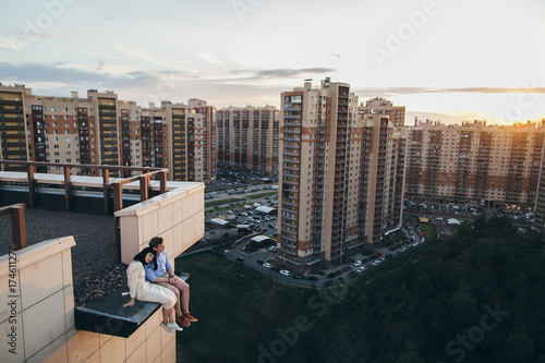 Young couple sitting on the adge of the rooftop photo
