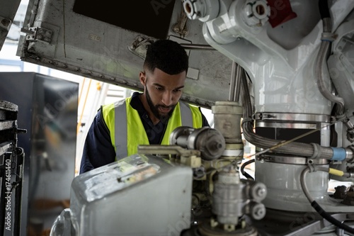 Male aircraft maintenance engineer examining engine of an photo