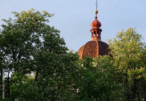 Detail of top of a tower seen among flowering trees in spring.