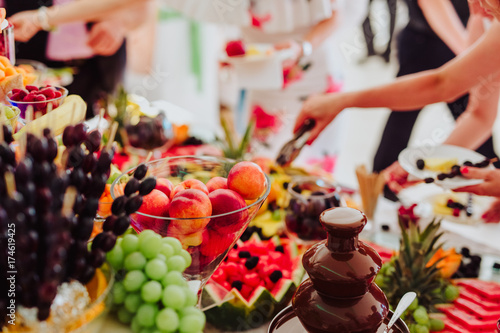 people group in the line catering buffet food indoor in luxury restaurant with colorful fruits and chocolate