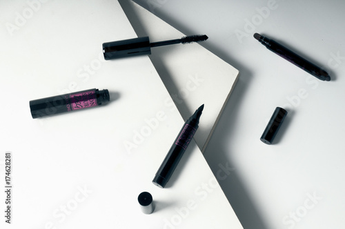 geometrical eye makeup products composition on white background, brow crayon, mascara, liner
