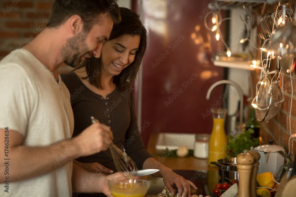 Happy young couple preparing food at home Happy young couple preparing food at home