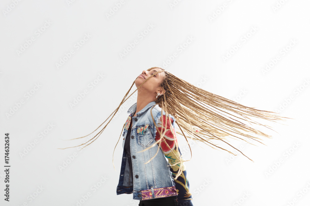 Beautiful young woman with african braids dancing on white background Beautiful young woman with african braids dancing on white background