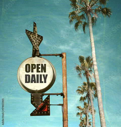 aged and worn vintage photo of open daily sign