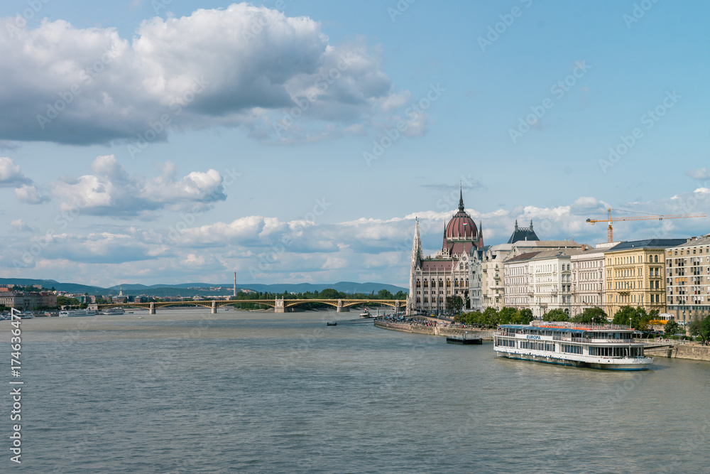 The Hungarian Parliament Building on the bank of the Danube in Budapest. Sunny day with clouds