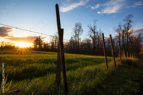 Barb Wired Fense in front of a farm field during a beautiful sunset. Taken in Surrey, Greater Vancouver, British Columbia, Canada.