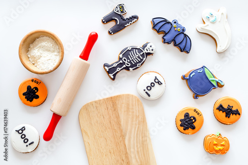 Bright halloween gingerbread cookies near rolling pin on white background top view mockup