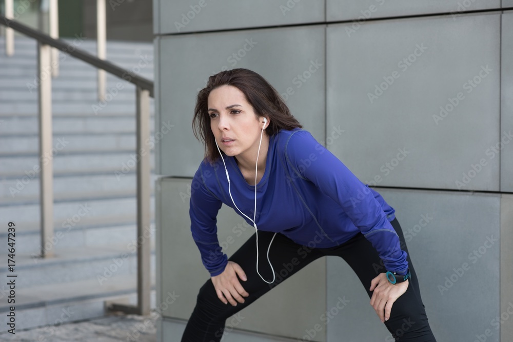 Woman performing stretching exercise outside building Woman performing stretching exercise outside building