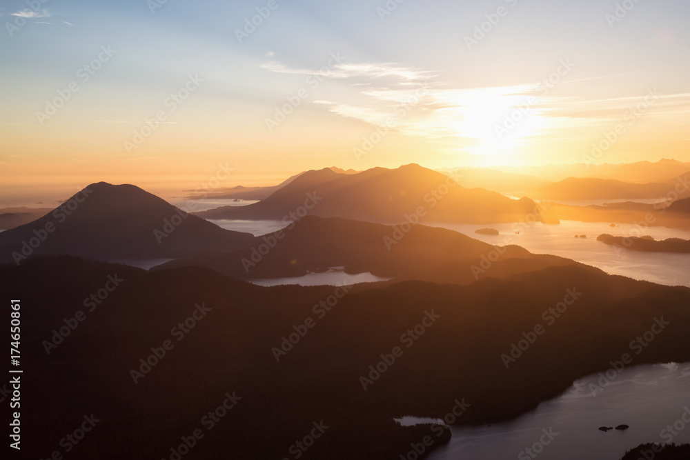 Beautiful aerial view of the Pacific Ocean Inlet around the Mountains near Tofino, Vancouver Island, British Columbia, Canada, during a sunny summer sunset.