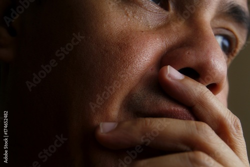 Man with his hand on his mouth and chin