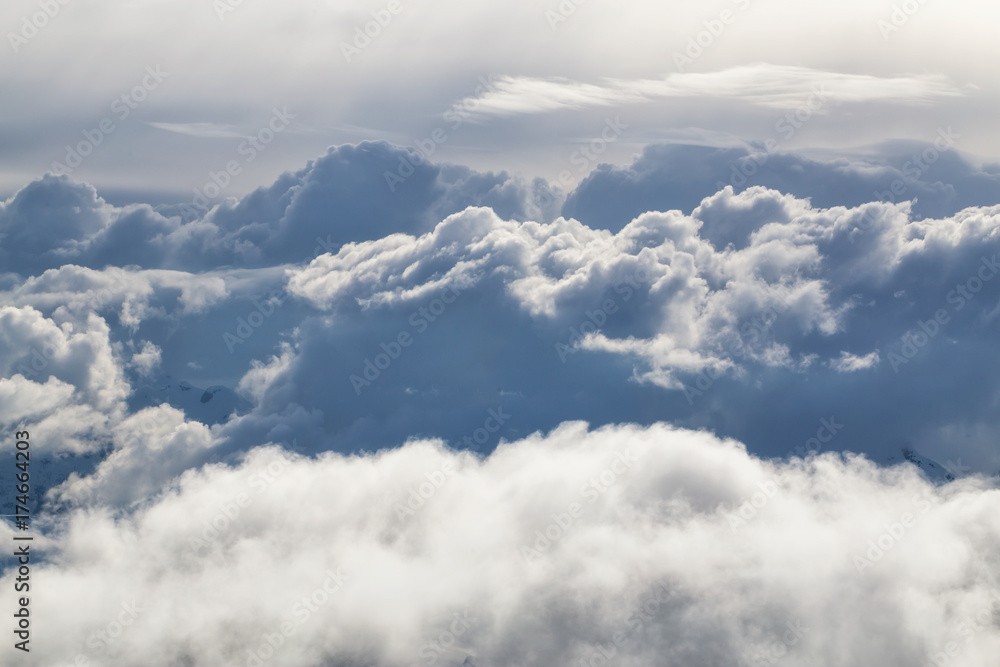 Above the clouds view of different cloud formations covering the remote mountains of British Columbia, Canada. Can be used for background.