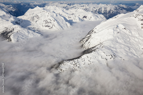 Beautiful aerial landscape view of the snow covered mountain range with a low level cloud. Taken in the remote area early morning North West from Vancouver, British Columbia, Canada. © edb3_16