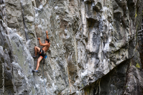 Rock climber climbing a steep rock face in Squamish, British Columbia, Canada.